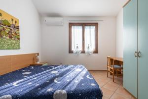 a bedroom with a bed with a blue comforter at Le Gemelle al 212 in Villaputzu +21 photos