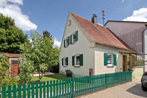 a white house with a green fence at Ferienhaus Frieda in Röfingen