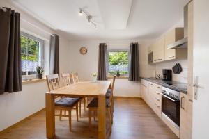 a kitchen and dining room with a wooden table and chairs at Ferienhaus Frieda in Röfingen