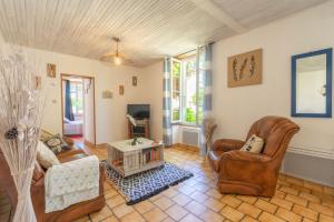 a living room with leather chairs and a table at La Desirade in Saint-Agnant