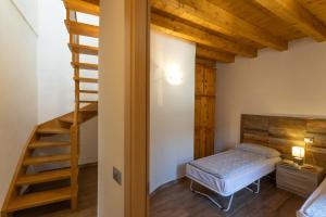 a bedroom with a bed and a wooden staircase at Artù in Tremosine Sul Garda