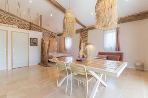 a dining room with a wooden table and chairs at Le Loft in Esparron