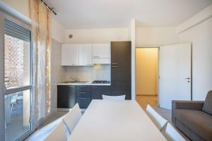 a living room with a white table and a kitchen at Appartamento Andromeda B4 in Bibione