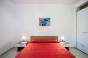 a bedroom with a large red bed with two night stands at Appartamento Andromeda B4 in Bibione