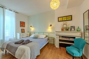 a bedroom with a bed and a chair and a fireplace at Maison 8 pers plein centre ville in Lesneven