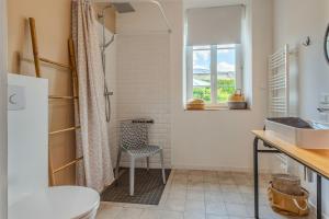 a bathroom with a shower and a chair at Maison 8 pers plein centre ville in Lesneven