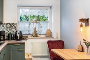 a kitchen with a table and a window at Ferienhaus Franz in Jemgum