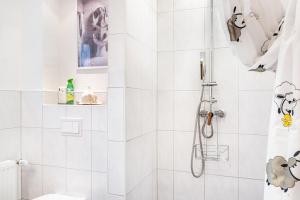 a white bathroom with a shower with a shower curtain at Ferienhaus Franz in Jemgum +19 photos