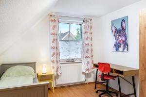 a bedroom with a desk and a bed and a window at Ferienhaus Franz in Jemgum