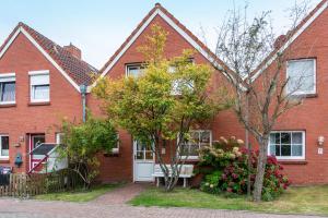 a red brick house with a white door at Ferienhaus Franz in Jemgum