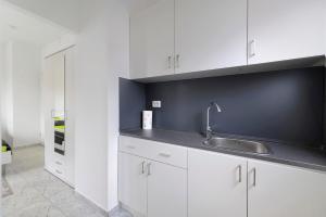 a kitchen with white cabinets and a sink at Haus Rosa in Albstadt