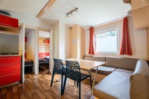 a living room with a couch and a table and chairs at Euro Mobil B16 in Boofzheim