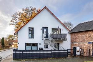 a white house with a black roof at Ferienwohnung Lampa in Wasbüttel
