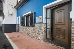 a door of a house with a brick wall and blue at Casa Marrero Abajo in La Guancha