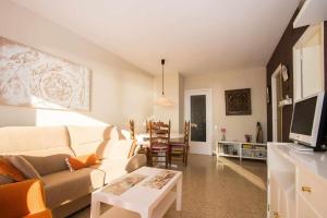 a living room with a couch and a table at Maresme Beach Apartment in Canet de Mar