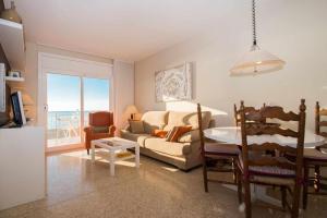 a living room with a couch and a table at Maresme Beach Apartment in Canet de Mar