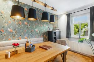 a dining room with a wooden table and black lights at Ferienhaus Altstadtchalet in Schmallenberg +28 photos