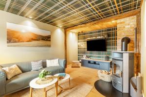 a living room with a couch and a tv at Ferienhaus Altstadtchalet in Schmallenberg