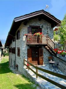 a stone house with a balcony and a porch at Petite Maison Tillier in Fenis