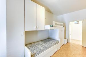ein kleines Zimmer mit weißen Schränken und einer Mikrowelle in der Unterkunft Leuca di Bolina in Santa Maria di Leuca