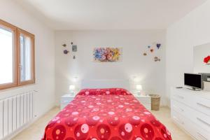 ein Schlafzimmer mit einem roten Bett und einer roten Bettdecke in der Unterkunft Leuca di Bolina in Santa Maria di Leuca
