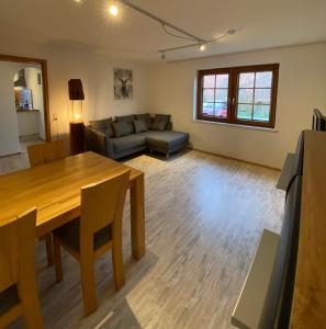 a living room with a table and a couch at Schwarzwaldnest Dachsberg in Wilfingen