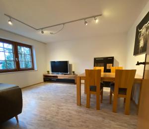 a living room with a table and a television at Schwarzwaldnest Dachsberg in Wilfingen