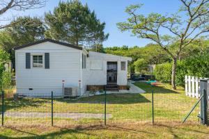 a small white house in a yard at Mh 229 La Tremblade in La Tremblade