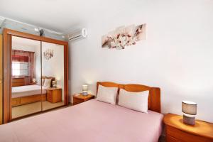a bedroom with a bed and a mirror at Ideal Villas Residence in Vila Nova De Cacela +24 photos