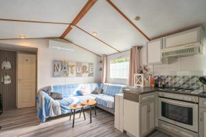 a living room with a blue couch and a kitchen at Mh 229 La Tremblade in La Tremblade +22 photos