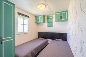 two beds in a room with green cabinets at Mh 229 La Tremblade in La Tremblade