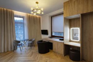 a room with a desk and chairs and a television at Willa Deptak in Krynica Zdrój
