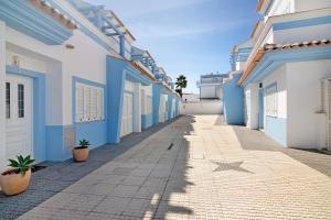 a street in a town with blue and white buildings at Ideal Villas Residence in Vila Nova De Cacela