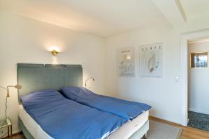 a bedroom with a large bed with blue sheets at Merkurblick in Baden-Baden