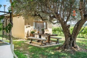 a picnic table under a tree next to a house at Ktima Dilberaki in Lixouri