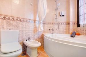 a bathroom with a toilet and a tub and a sink at Vista de Lobos in Corralejo +20 photos