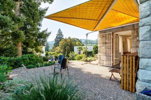 a patio with a yellow umbrella in a garden at Merkurblick in Baden-Baden