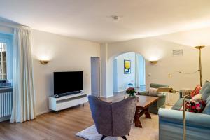 a living room with a tv and a table at Merkurblick in Baden-Baden