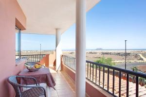 a balcony with a table and chairs and a view of the desert at Vista de Lobos in Corralejo