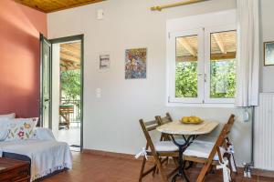 a room with a table and chairs and a bed at Ktima Dilberaki in Lixouri