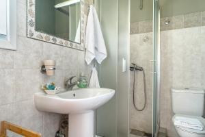 a bathroom with a sink and a toilet and a shower at Ktima Dilberaki in Lixouri +19 photos