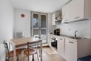 a kitchen with a table and chairs and a sink at Suite Strada Persa in Pavia