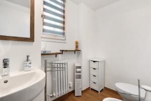 a white bathroom with a sink and a toilet at Suite Strada Persa in Pavia