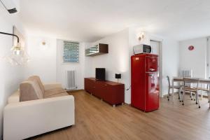 a living room with a couch and a red refrigerator at Suite Strada Persa in Pavia +12 photos