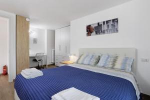 a bedroom with a blue bed in a white room at Suite Strada Persa in Pavia