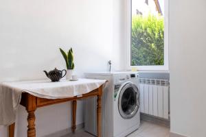 a laundry room with a washing machine and a table at Casa Maria in Porto Ceresio