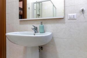 a white sink in a bathroom with a mirror at Casa Maria in Porto Ceresio +18 photos