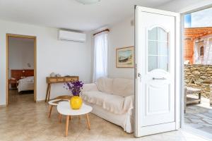 a living room with a white couch and a table at Anemologio 301 Tinos in Agios Ioannis