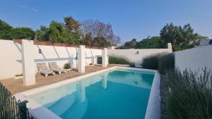 a swimming pool in a yard next to a house at De Kothuize 12 in Graaff-Reinet