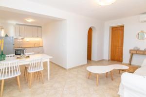 a kitchen and living room with a table and chairs at Anemologio 301 Tinos in Agios Ioannis